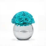 Clear glass Minoan Homey vase with turquoise artificial roses, minimalist flower arrangement