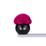 Glossy black vase with lush pink rose bouquet
