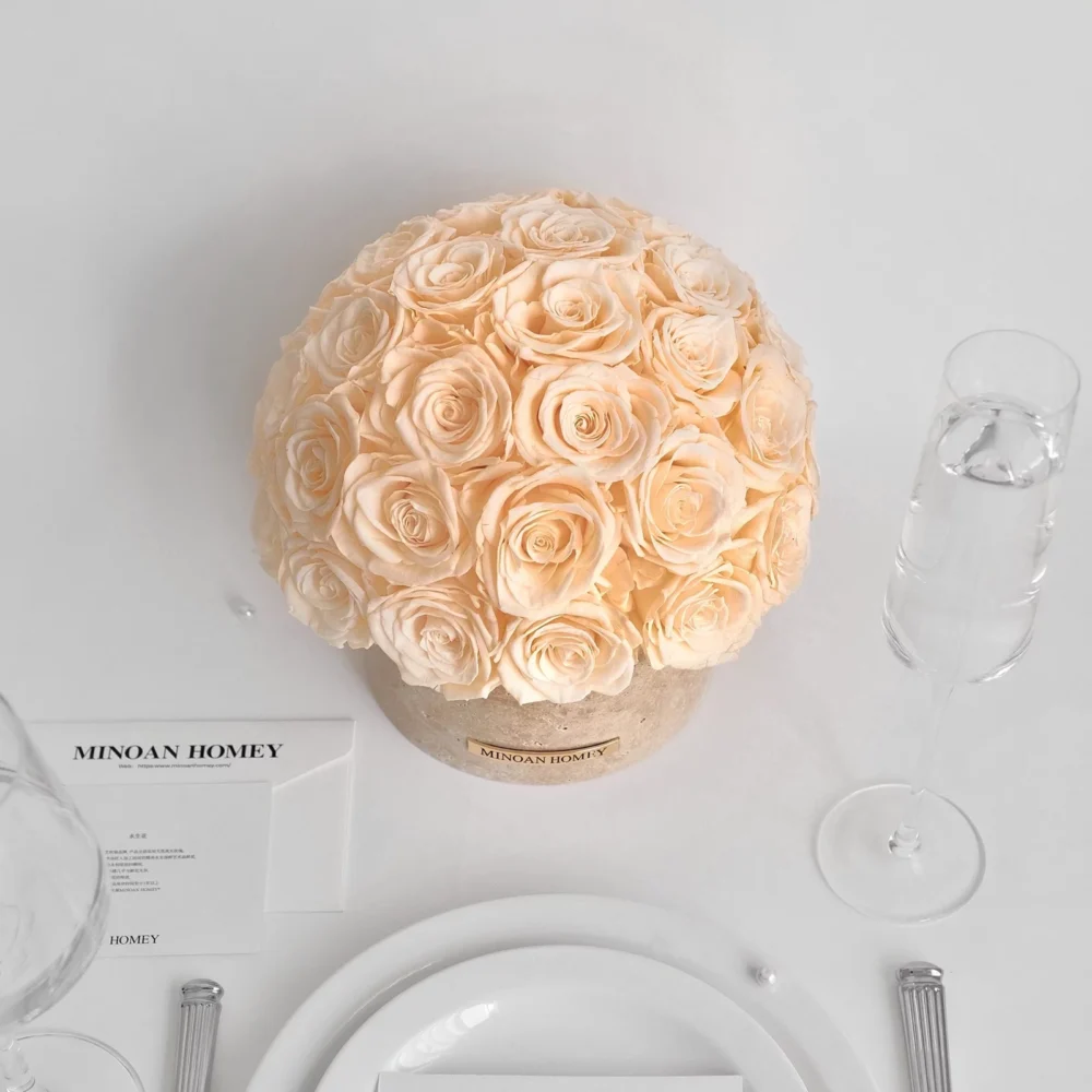 Minimalist elegant table setting with beige rose bouquet on cream box, white plate, and silverware
