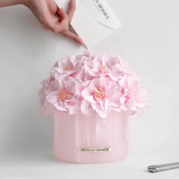 Pink hydrangea bouquet in glass vase with white glove